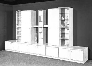 Anbauwand : Dresden-Hellerau. VEB Deutsche Werkstätten Hellerau. Hausmesse, 1986. Anbauwand. Holz, folienbeschichtet in Kirschbaumholzoptik (1986; VEB Deutsche Werkstätten Hellerau)