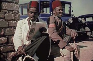 Straßenszene in Ägypten : Reisefotos Ägypten. Zwei an einer Straße sitzende Männer mit roter Fese (vielleicht ein Museumsangestellter)