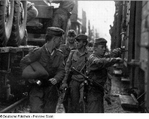 Deutschland . Truppenübungsplatz Klietz. Nationale Volksarmee - Landstreitkräfte. Truppenverlegung per Eisenbahnmarsch. Soldaten zwischen zwei Militärzügen (links Flachwagen mit Militärtechnik, rechts Mannschaftswagen)