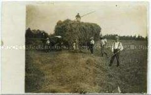 Bauernfamilie mit beladenem Heuwagen