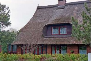 Am Teich / Ecke Dorfstraße: giebelständige Fachwerkkate mit Reetdach: Teilansicht: Traufseite, breite Gaube: hinten links flacher Anbau