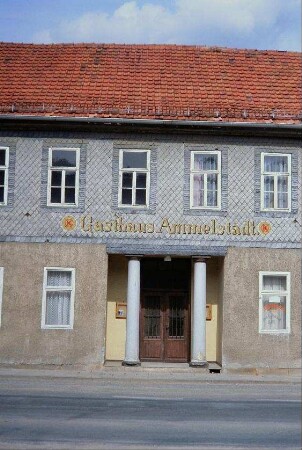 Gasthaus Ammelstädt ist farbig auf Schieferwand aufgemalt; Konsum-Zeichen; zwei Säulen im Portal