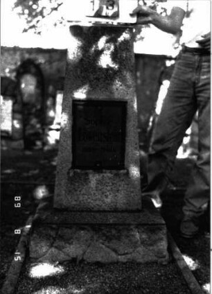 Grabstein 13 (Index: 100105429) Material: Granit, Glasplatte Zustand: gut Maße HxBxT: 117x31x20 cm Beschreibung: Obelisk, Rusticasockel, rechteckige Schriftplatte: Grabstein 13