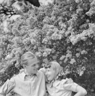Elisabeth Gremmler und ein befreundeter Mann vor einem Fliederstrauch