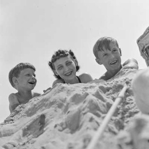 Elisabeth Gremmler, ihr Kind und ein weiterer Junge liegen am Strand