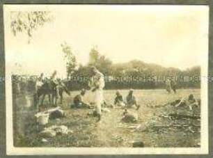 Askari und afrikanische Träger bei der Rast