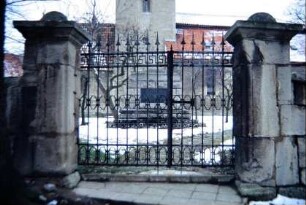 altes schmiedeeisernes Tor zum Kirchhof, dahinter Kriegerdenkmal