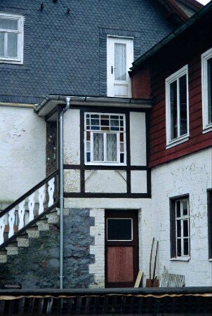 verwinkelte Anbauten an der Giebelwand eines Hauses, schönes Fenster im Windfang