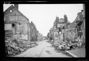 Saint-Quentin (Dep. Aisne, Frankreich): "Straße" mit Gleis, im Vordergrund Schutthaufen, im Hintergrund beschädigte Gebäude