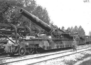 Erster Weltkrieg : Deutscher Soldat mit Gehstock vor einer Kanone auf Güterwagen