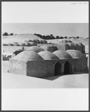 Dorf der Souf-Region : Ein Dorf der Souf-Region in der Nähe der algerischen Stadt El Oued. Die Gebäude weisen die für die Souf-Region charakteristischen Kuppeldächer auf. Im Hintergrund sind neben der Oase Wanderdünen erkennbar