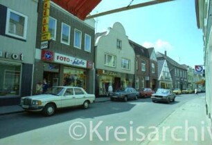 Hindenburgstraße 24 bis 30: Häuser von links nach rechts: Südseite, zwischen Hagenstraße und Markt: von links Fotogeschäft Scholz, Geschäft Hans Lübcke, Geschäftsstelle BVV, Eiscafé Italia