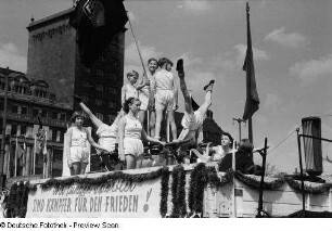 Leipzig. Kinder machen Turnübungen auf der Ladefläche eines Transporters auf dem Karl-Marx-Platz bei der Demonstration zum 1. Mai, ein Kind hält eine Fahne der Freien Deutschen Jugend