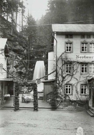 Restaurant "Beuthenfall" im Kirnitzschtal, Straßenansicht mit Wasserfall