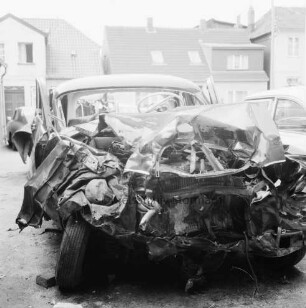 B 404: nach Verkehrsunfall bei Klinken: [Zusammenstoß von zwei Pkws]: schrottreifer Unfall-Pkw auf Abstellplatz: rechts und hinten zwei Autos [angeschnitten]: hinten Häuser