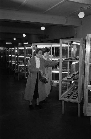 Zwei Besucherinnen der Leipziger Herbstmesse 1955 betrachten in Vitrinen ausgestellte Gesteinsproben