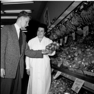 Lebensmittelmarkt. Verkäuferin mit Kunde vor dem Obststand