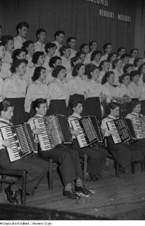 Chor des VEB Farben- und Lackfabrik bei der Endveranstaltung des Kreisausscheides der Volkskunst entgegen, im Vordergrund Akkordeonspieler