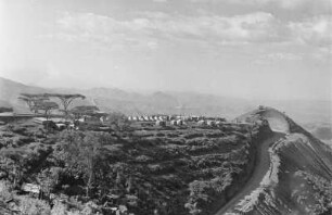 Abfall des Simien Gebirges : Bergstraße im Simien Gebirge in Richtung Debark. Blick auf ein Zeltlager, möglicherweise ein Straßenarbeitercamp.