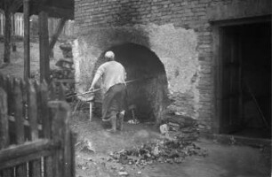 Brotbacken : Frau an einem Brotbackofen