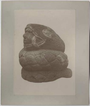 Steinfigur. Schlange mit menschlichem Kopf im Maul.