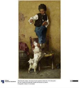 Knabe, mit einem Hund spielend