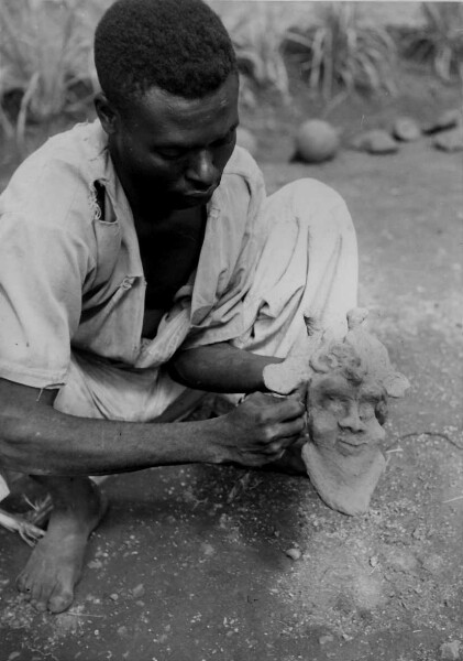 Foumban. Artisan modelant un masque en cire pour servir de modele au masque en cuivre