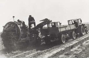 Kartoffelernte. Kartoffelvollerntemaschine mit Zugmaschine und Traktor mit Pritschenanhänger in Parallelfahrt
