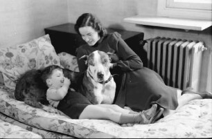 Bukarest: Haus des + Schriftleiters Wilhelm Müller, Frau Müller mit Junge und Hund auf Sofa, liegend