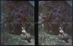 Auf einem Steinkrug sitzende Frau in einem Garten in Miraflores