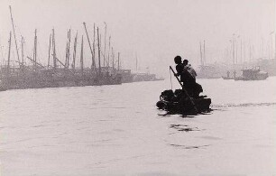 Mutter mit Kind, ein kleines Boot im Hafen steuernd, Hongkong