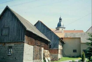 Scheune und andere Wirtschaftsgebäude, dahinter der Kirchturm