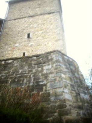 Evangelische Kirche - Kirchturm (gotisch gegründet) von Süden mit Schießscharten (Schlitzscharten) in den Mittelgeschossen über Kirchhofmauer