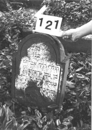 Grabstein 121 (Index: 100114289) Material: Sandstein Zustand: stark abgeblättert und verwittert mit Textverlust Maße HxBxT: 53x36x10 cm Beschreibung: Stele, eingezogener Rundbogenabschluß Besonderheit: Kindergrab: Grabstein 121