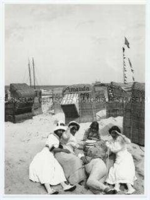 Am Strand - Familie im Sand liegend
