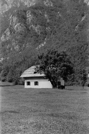 Berghütte : Kleine Hütte am Fuße eines Felsmassivs.