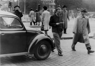 Im Straßenverkehr. Unbekümmert u. nicht ungefährlich überqueren Passanten die Fahrbahn