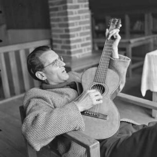 Mann mit Brille spielt Gitarre