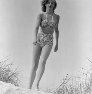 Frau im Bikini mit Sonnenbrille am Strand