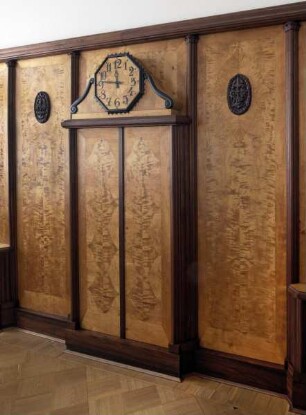 Wandvertäfelung mit Schrank und Uhr