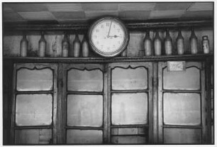 Darjeeling. Vitrine mit Uhr und Flaschen