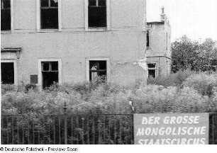 Ruine eines Wohnhauses, am Zaun Werbung für den Mongolischen Staatszirkus