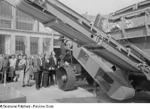 Besucher der Technischen Messe 1953 bei der Vorführung eines Nutzfahrzeugs mit Förderband