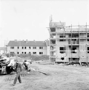 Wohnungsbau: Wohngebiet Kellerberg-Süd: Wohnblocks im Bau: Rohbauten der Neuen Lübeck-Südholsteinischen Baugenossenschaft, teilweise mit Gerüsten: vorn links Anhänger mit Brettern: Arbeiter beim Entladen