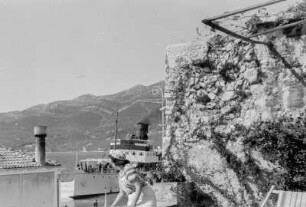 Dampfschiff : Blick von einer Terrasse auf ein an der Stadt vorbei fahrendes Schiff.