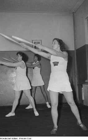 Sportlerinnen während einer Gymnastikübung mit Keulen
