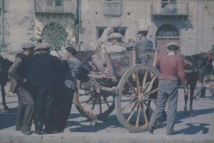 Reisefotos Italien. Sizilien. Männer an und auf einem mit historischen Szenen bemalten Karren