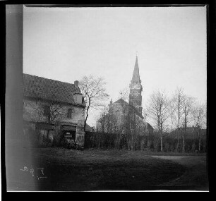 Phalempin (Dep. Nord, Frankreich): "Kirche [Saint-Christophe] von Phalempin", im Vordergrund Personenkraftwagen in der Garage eines Hauses (Distanzaufnahme)