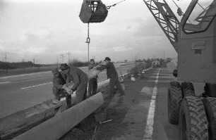Montage von Leitplanken aus Stahlbeton auf dem Mittelstreifen der Autobahn zwischen Rüppurr und Ettlingen.