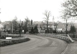 Radeburg. Meißner Berg. Blick zum Stadtzentrum. Im Vordergrund Straßenkurve mit Schutzplanken (beidseitig)